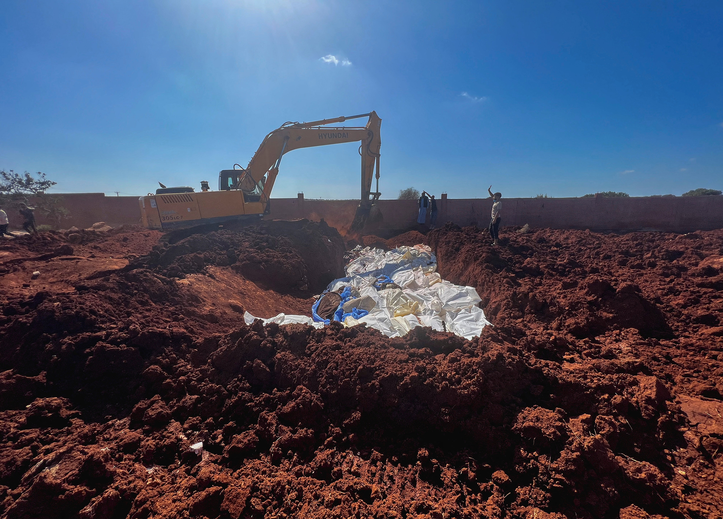 Bodies of victims are placed at a mass grave after a powerful storm and heavy rainfall hit Libya, in Derna on Sept. 12.