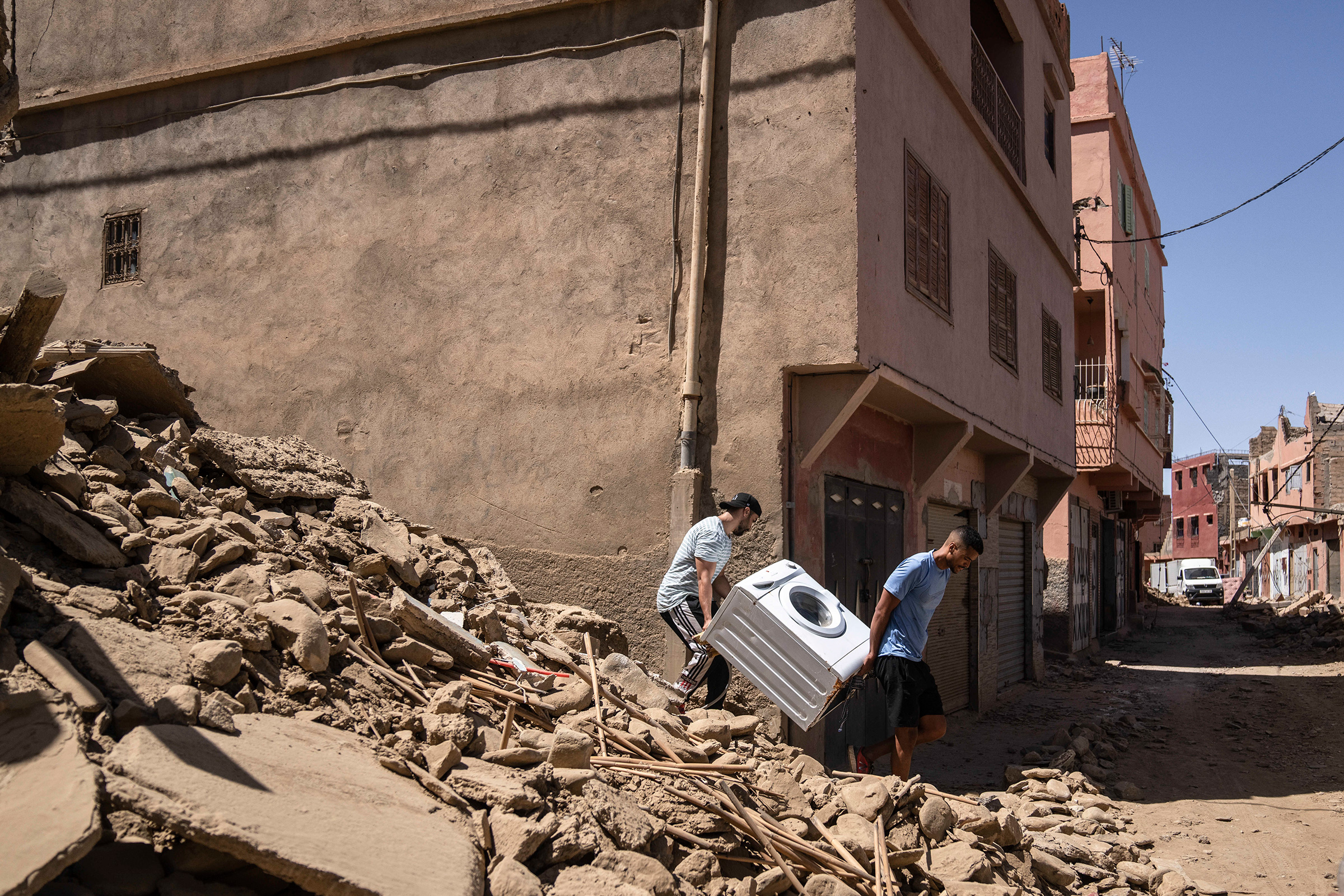 People recover a washing machine from their home that was damaged by the earthquake, in the town of Amizmiz, near Marrakech, Morocco, on Sept. 10. An aftershock rattled Moroccans on Sunday as they prayed for victims of the nation’s strongest earthquake in more than a century and toiled to rescue survivors while soldiers and workers brought water and supplies to desperate mountain villages in ruins.  (Mosa'ab Elshamy—AP)