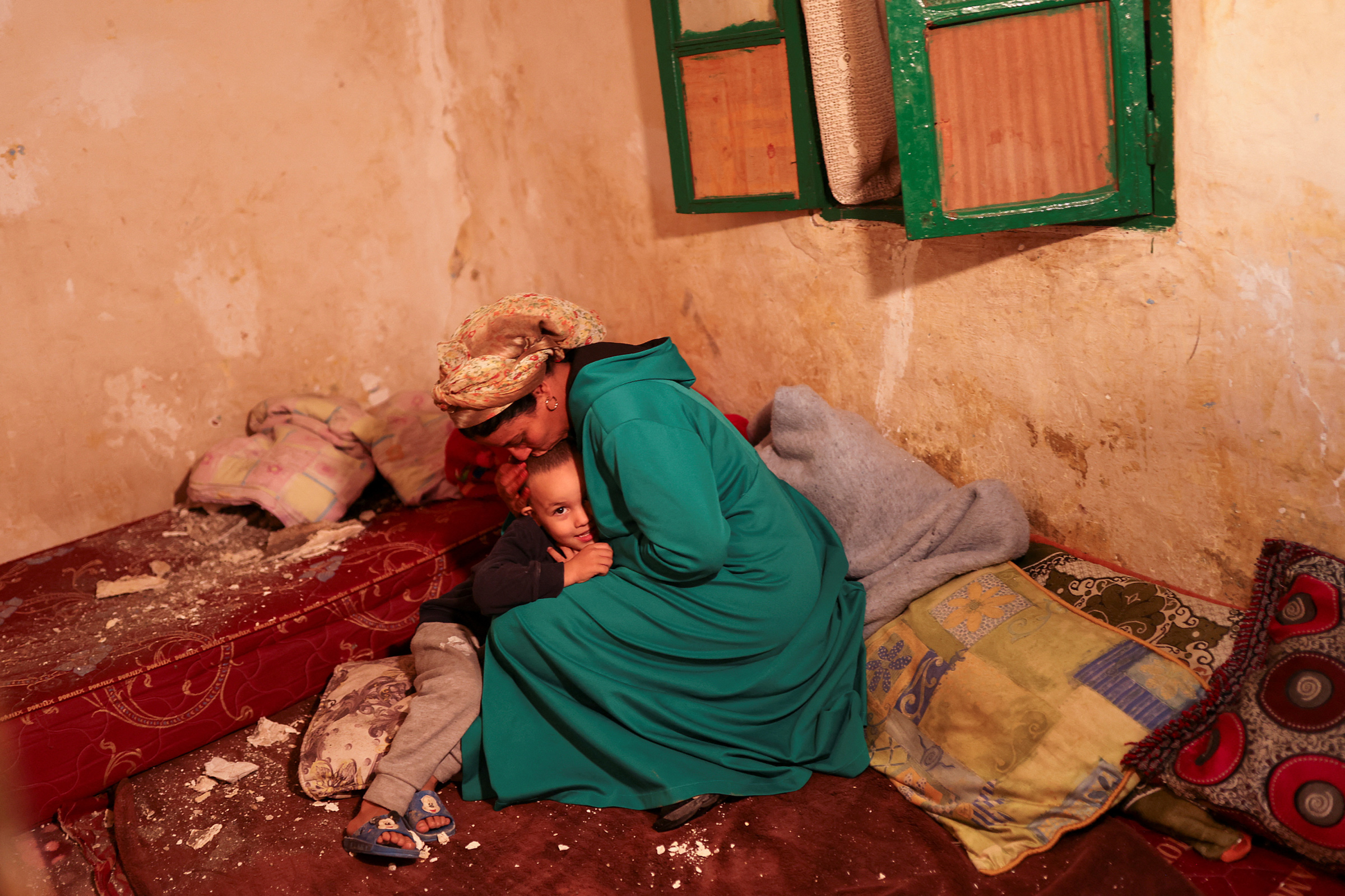 Hasna, 44, kisses her son Mohamed Jad, 5, inside their damaged house in Moulay Brahim village, in the province of Al Haouz, on Sept. 9. (Nacho Doce—Reuters)