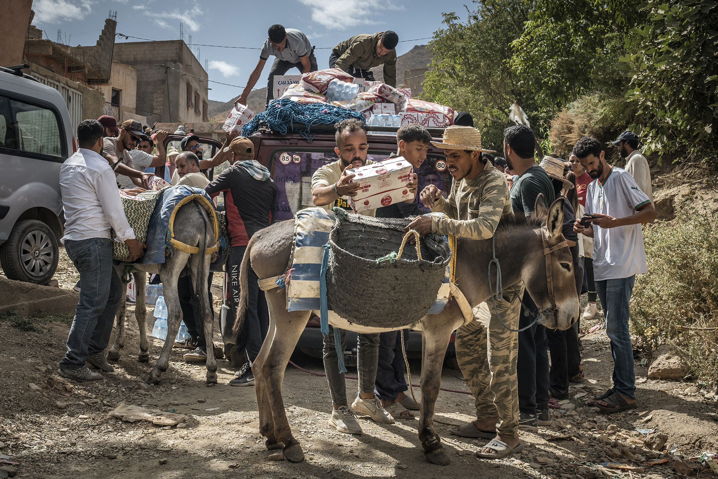 People load aid to donkeys to transport to hardly accessible houses in Douar Tnirt village in the Atlas Mountains in the hard-hit Al Haouz province on Sept. 10. (Sergey Ponomarev—The New York Times/Redux)