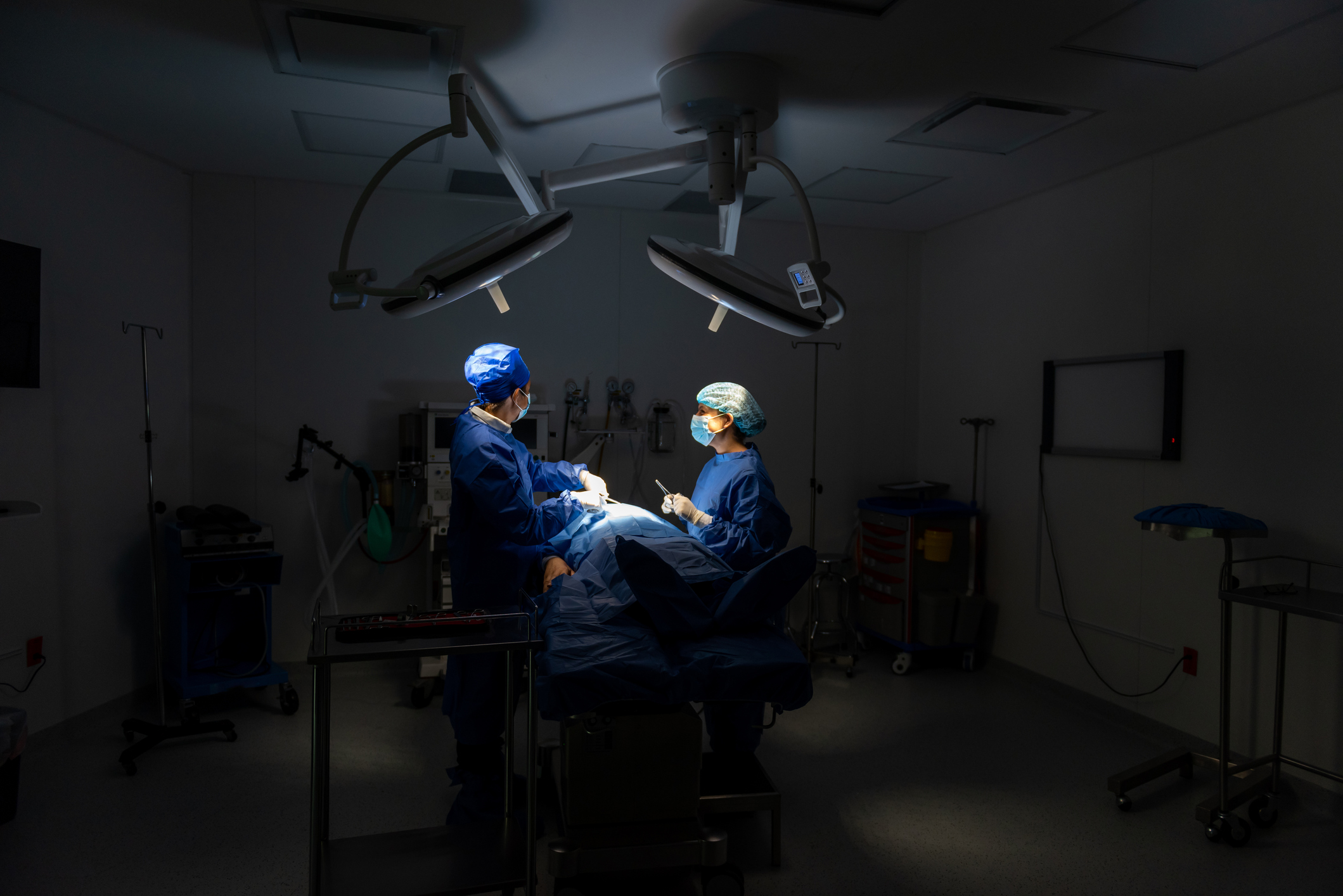 Doctors in surgery with patient in operating room.