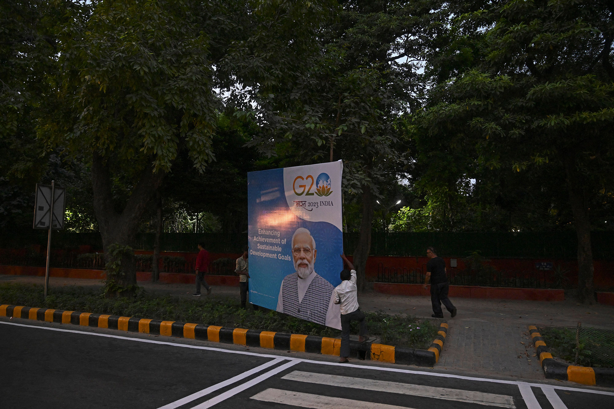 Workers install a billboard with a portrait of India' Prime Minister Narendra Modi ahead of the G20 summit in New Delhi on Sept. 8.  (Tauseef Mustafa—AFP/Getty Images)