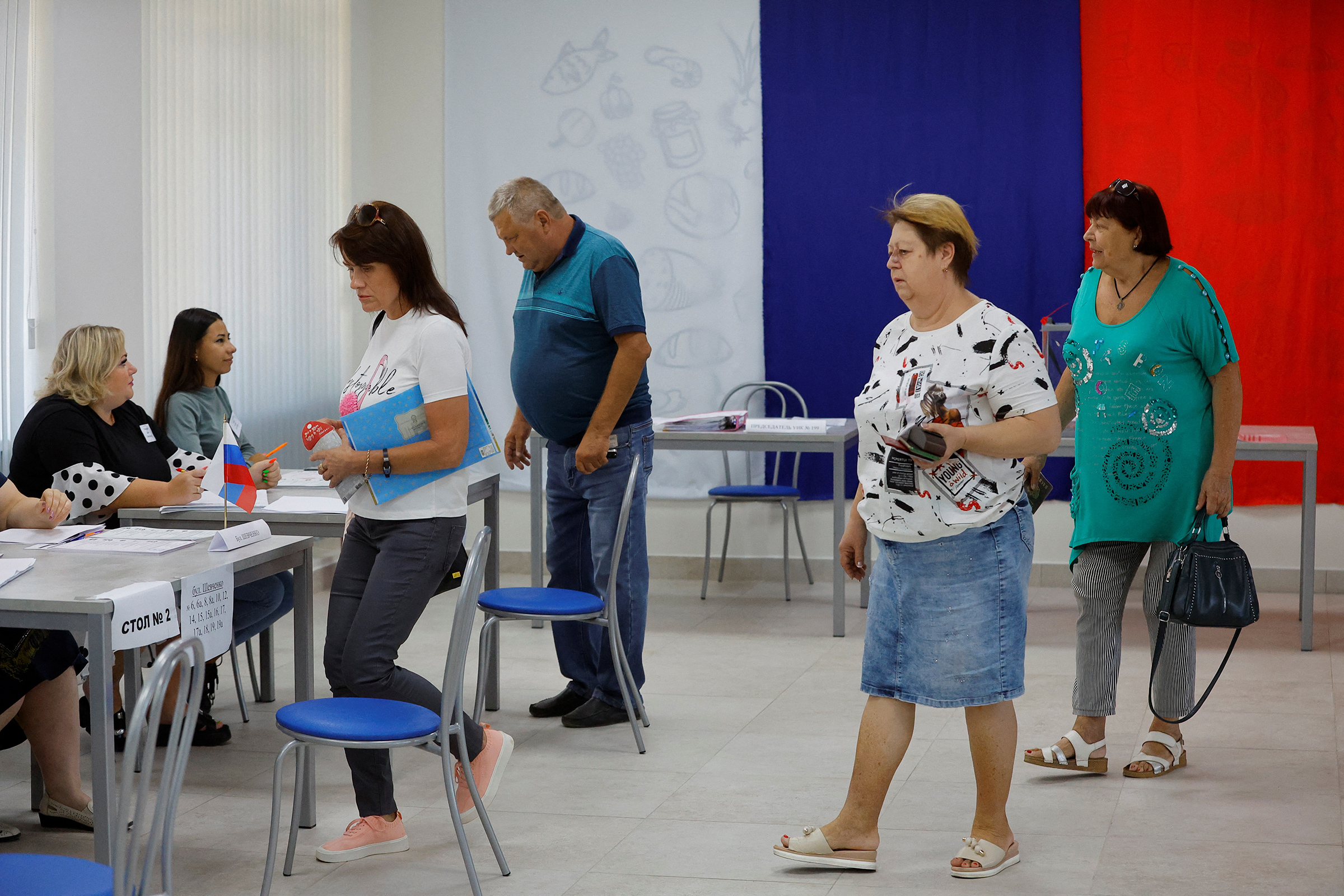 Voters walk toward members of an electoral commission to receive their ballots at a polling station during local elections held by the Russian-installed authorities in Donetsk, on Sept. 8.  (Alexander Ermochenko—Reuters)
