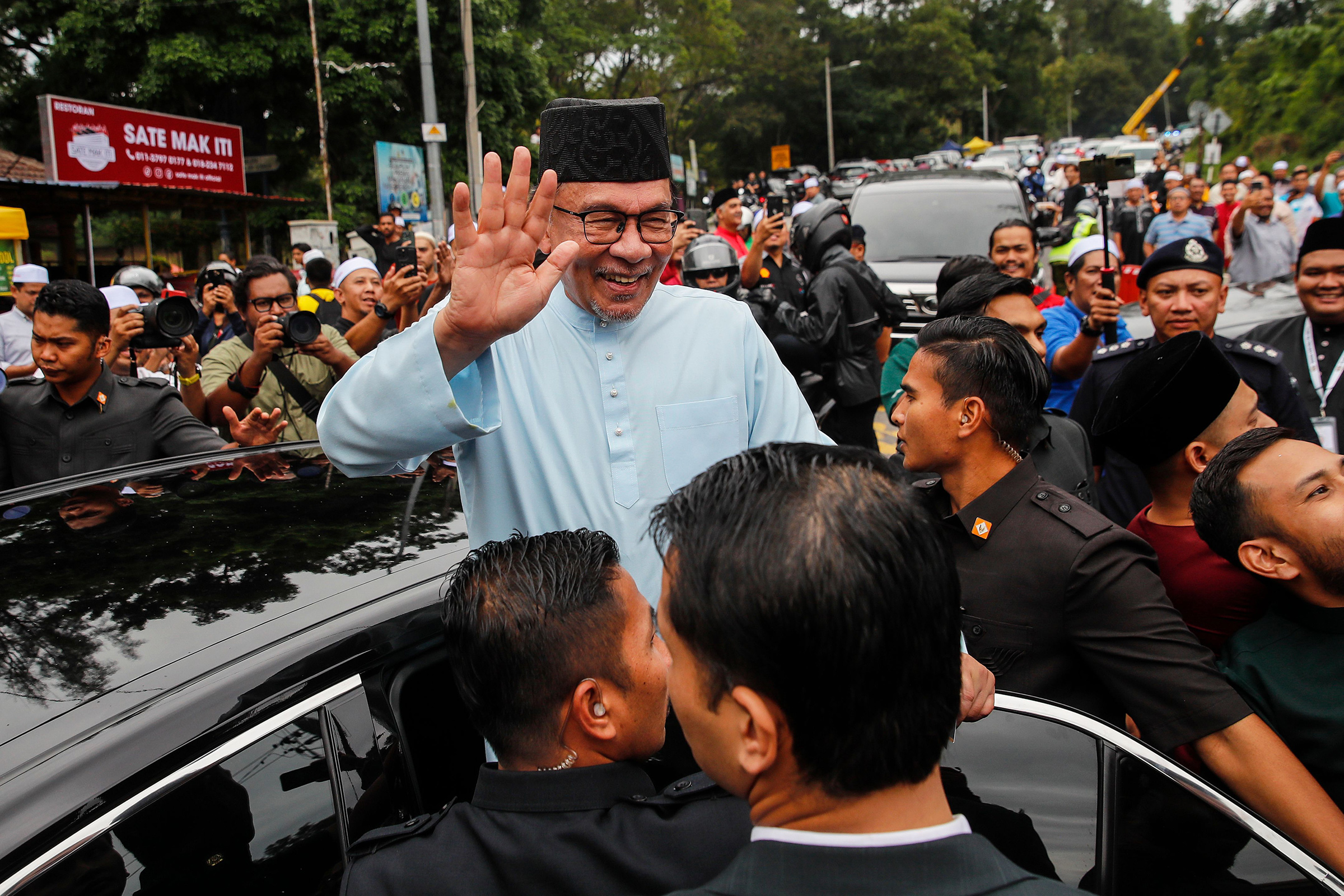Anwar waves as he leaves after Friday prayers at a mosque in Gombak, outside Kuala Lumpur, Malaysia, on July 14.