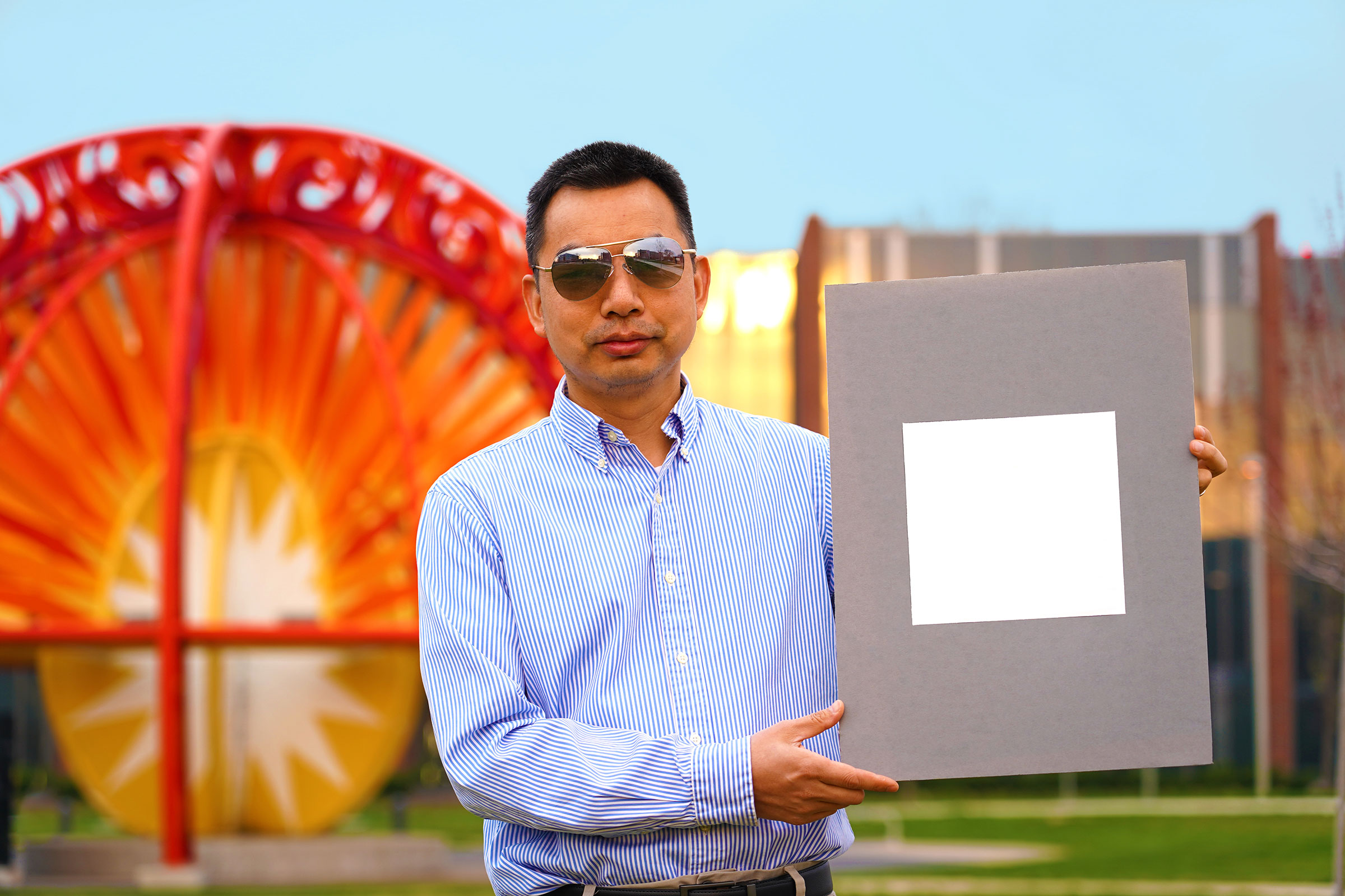 Xiulin Ruan, a Purdue University professor of mechanical engineering, holds up his lab's sample of the whitest paint on record. (Jared Pike—Purdue University)