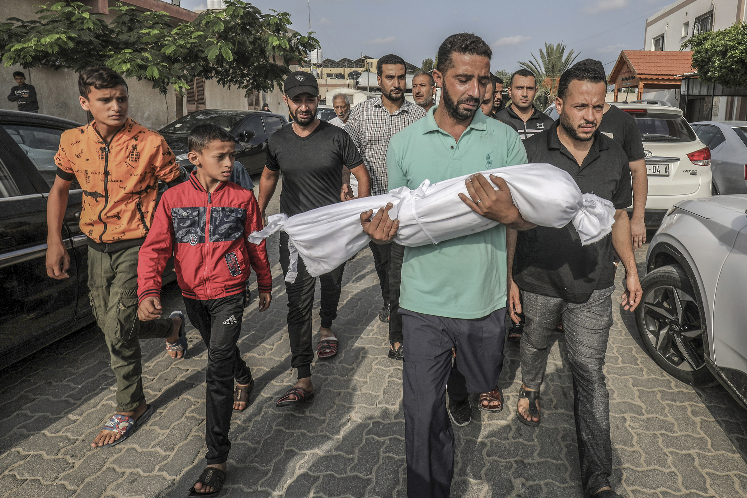 A man carries the body of his 3-year-old son, Amir Qanan, who was killed in an Israeli airstrike on their home in Khan Yunis, Gaza, on 10 Oct. 10, 2023.