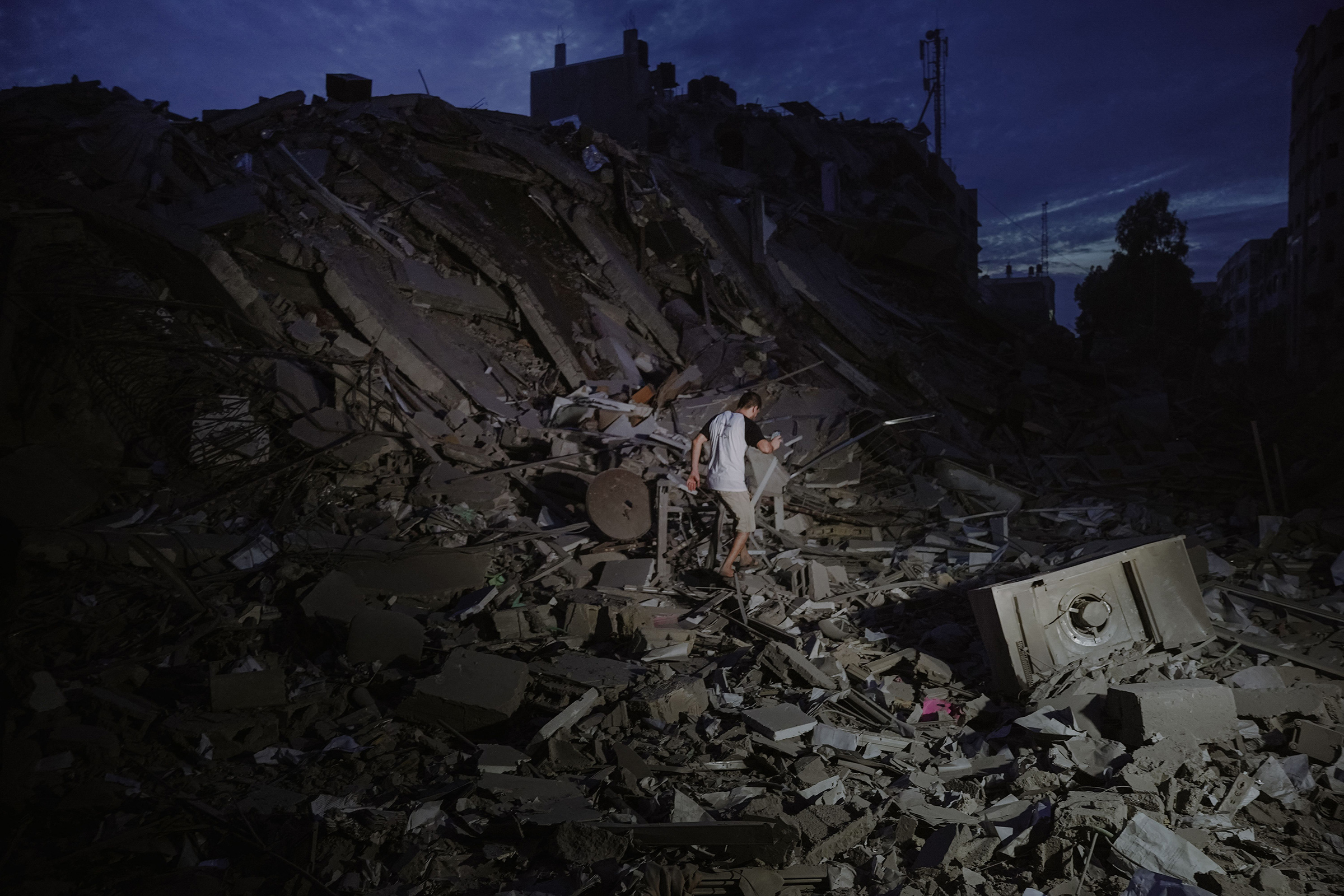 A man walks amidst the ruins of a building in Gaza City that was hit by an Israeli airstrike, Oct. 7.