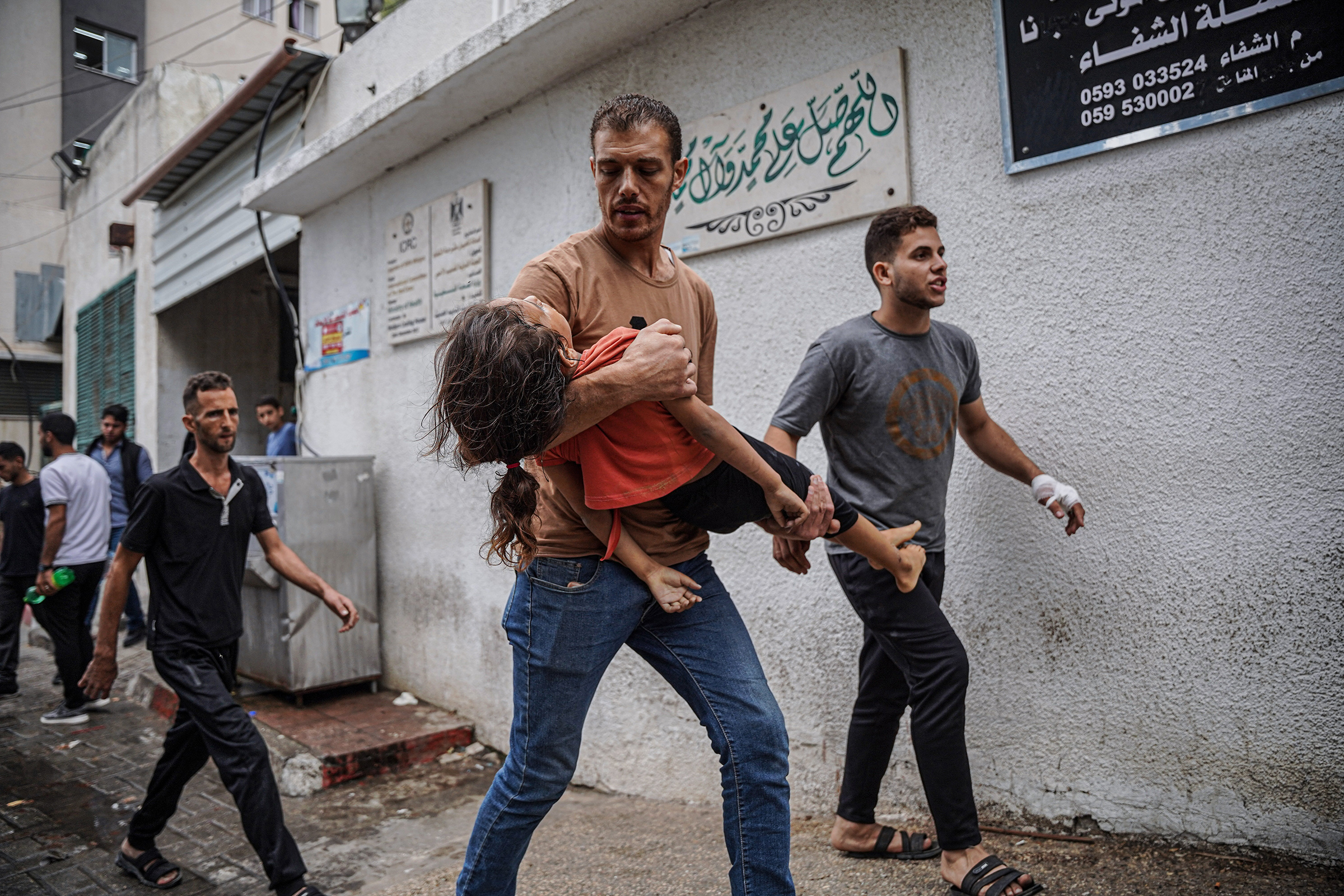 A Palestinian man carrying his daughter's body near Al-Shifa hospital, Oct. 9. She was killed by an airstrike.