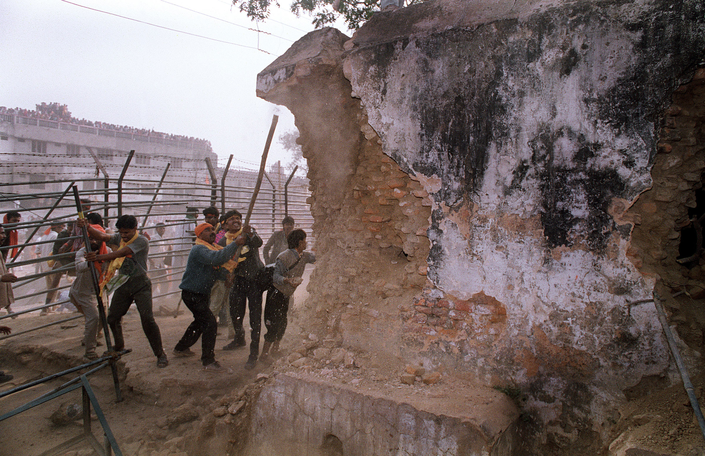 Hindu fundamentalists attack the wall of the 16th century Babri Masjid Mosque with iron rods