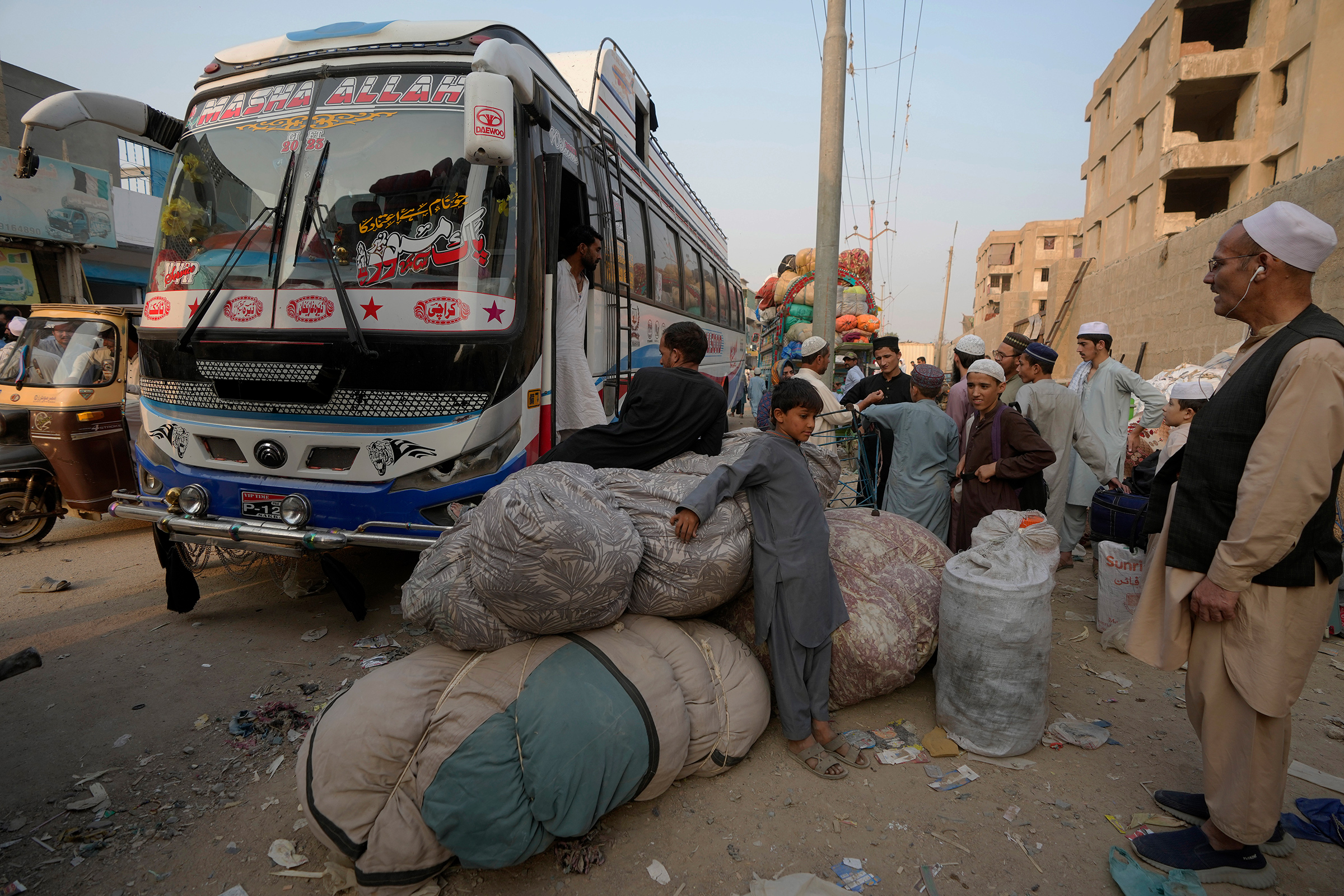 Afghan families wait to board in buses to depart for their homeland, in Karachi, Pakistan on Oct. 30.