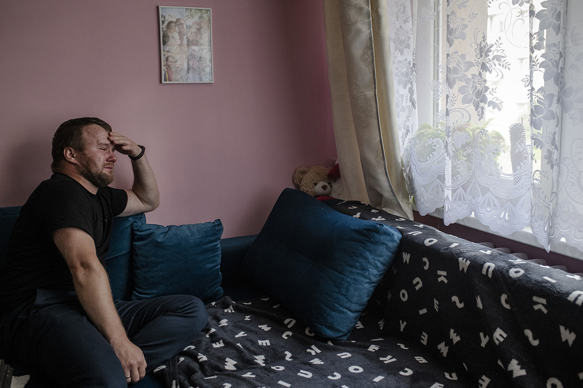 Krzysztof Sowinski sits on his couch in Dabrowa Gornicza, Poland, on July 31, where his late wife Marta rested in the days before she died. Over a year after Marta’s death, Krzysztof has not moved anything from this couch or his display of ultrasound photos and other memorabilia.