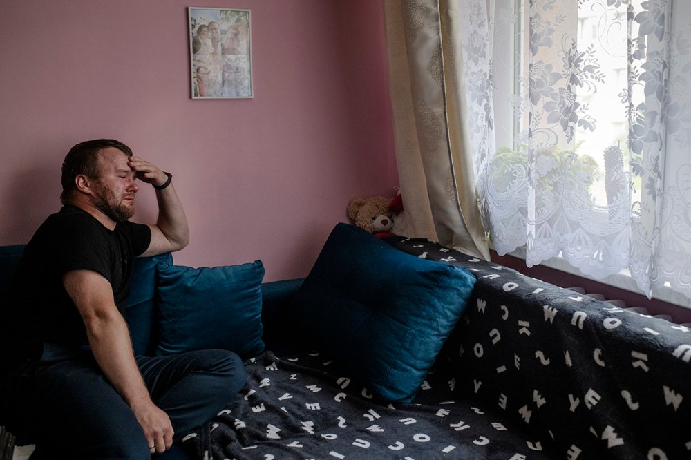 Krzysztof Sowinski sits on his couch in Dabrowa Gornicza, Poland, on July 31, where his late wife Marta rested in the days before she died. Over a year after Marta’s death, Krzysztof  has not moved anything from this couch or his display of ultrasound photos and other memorabilia.