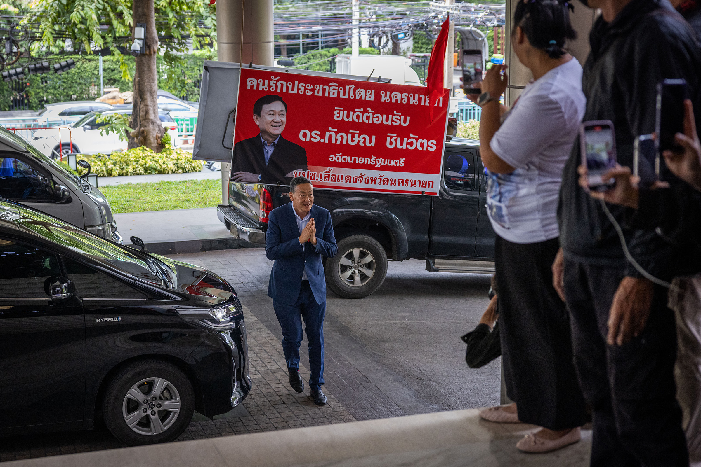 Srettha Thavisin greets supporters in front of an image of former Thai Prime Minister Thaksin Shinawatra as he arrives at Pheu Thai Party's headquarters on Aug. 22 in Bangkok.