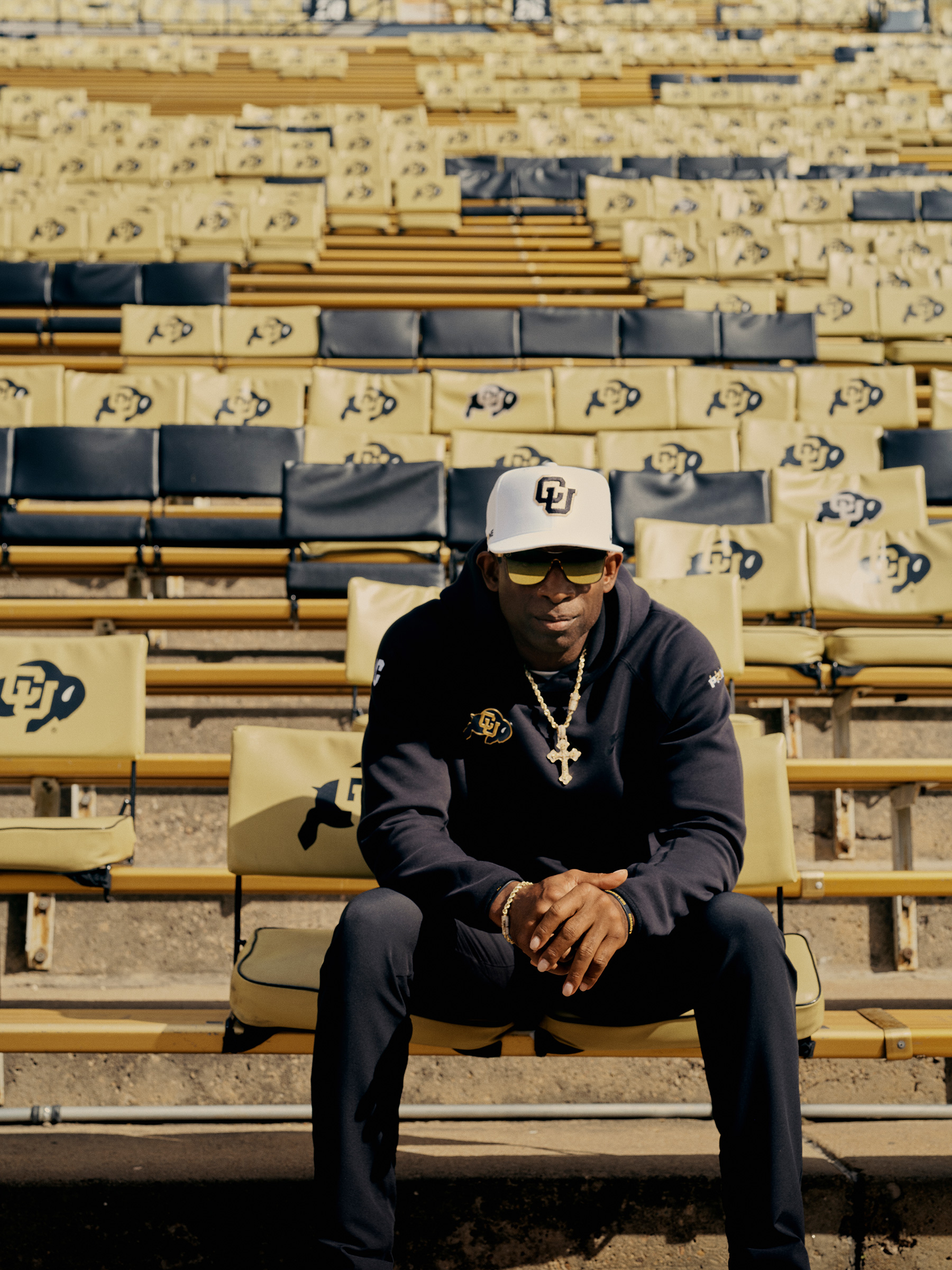 Coach Deion Sanders seated at Folsom Field in the campus of Colorado University
