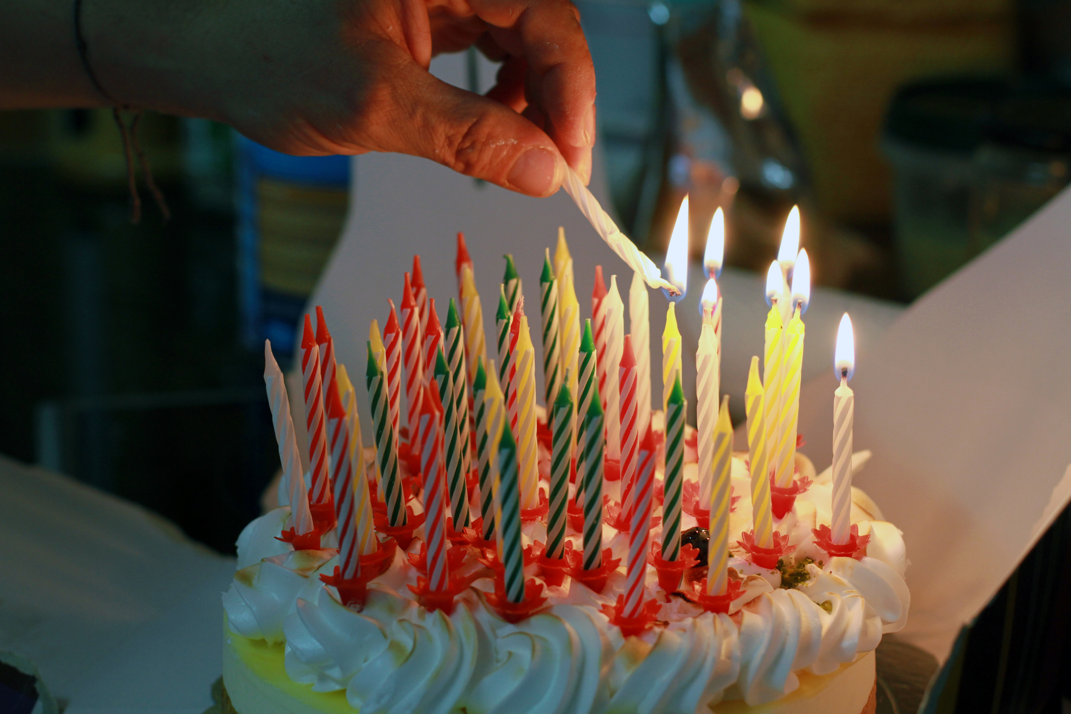 Hand burning candles on birthday cake