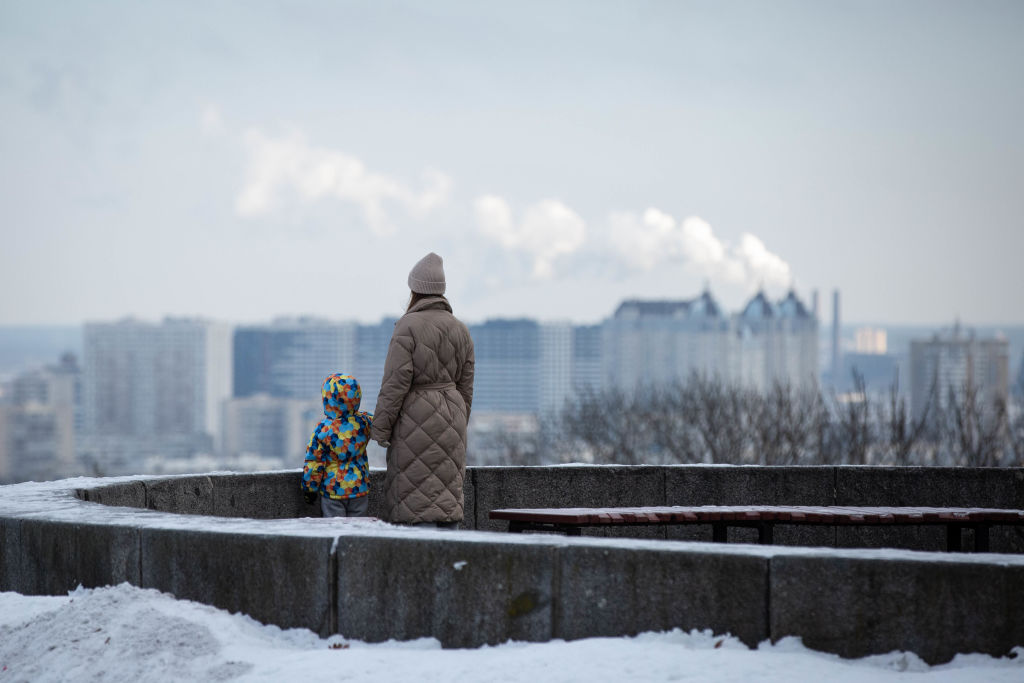 A woman and a child look at the left-bank districts of Kyiv