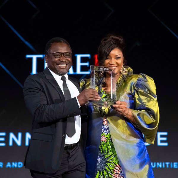 Keneddy Odede accepts an award from Omotola Jalade-Ekeinde at the Time100 Impact Awards.