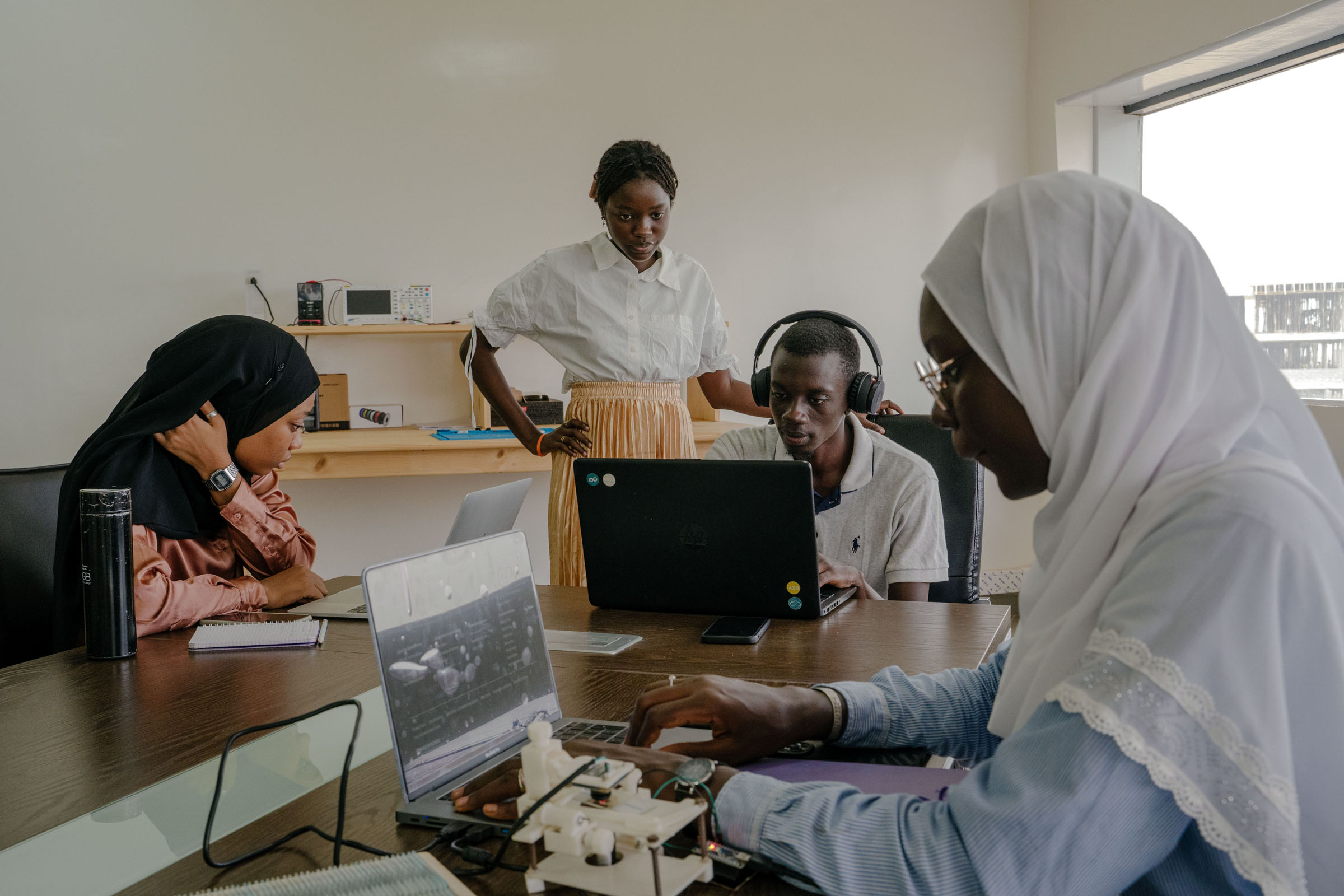 Rokhaya Diagne, right, a computer science major, works on a project for her internship at the Institute for Health Research, Epidemiological Surveillance and Training in Dianiamdio, Senegal, on Aug. 7, 2023. Like many other young people in Africa's tech boom, Diagne is at the center of a growing, educated middle class raising even more educated children who, with each tap on a keyboard, have adopted a sense that the continent's biggest problems can be solved. (Carmen Abd Ali—The New York Times/Redux)