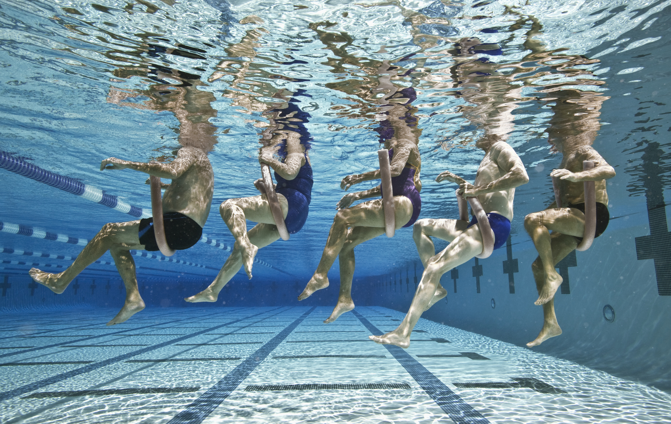 Five senior people swimming in a pool