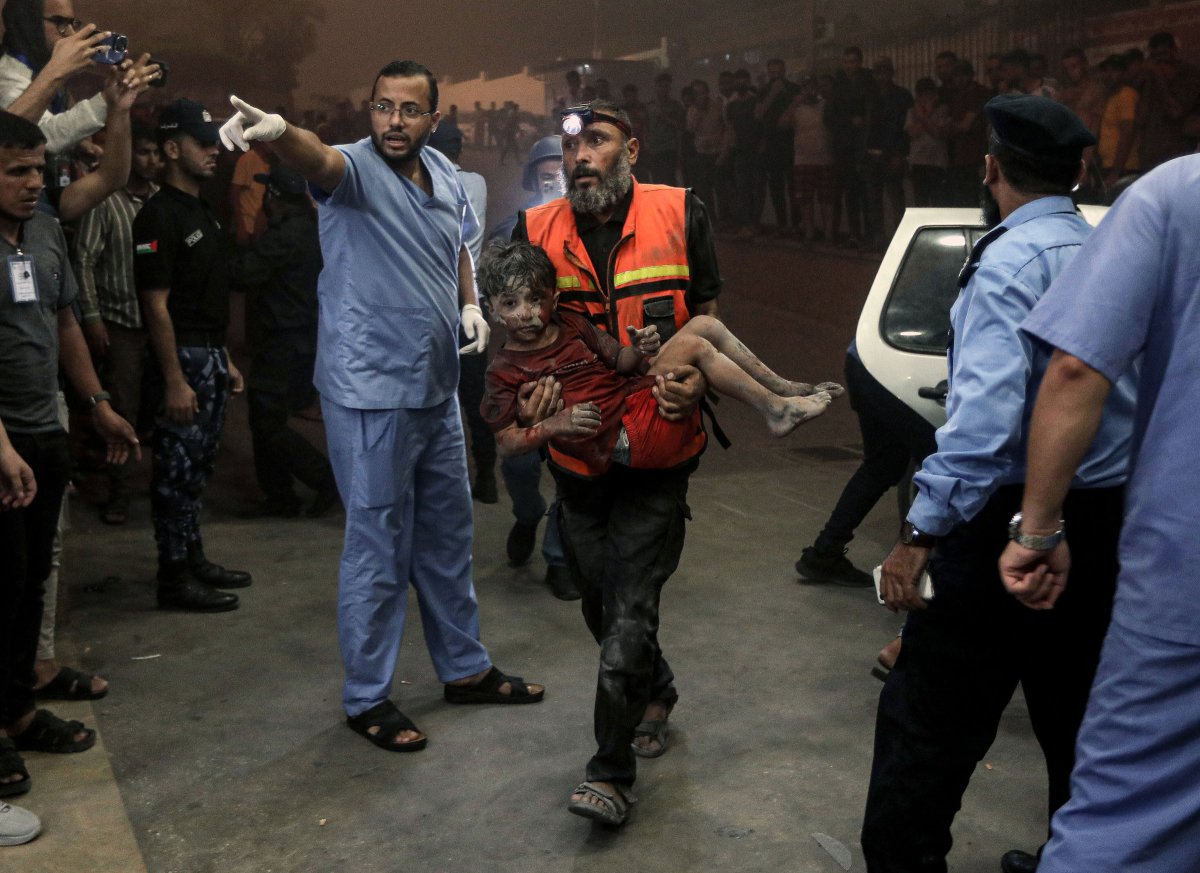 An injured child is rushed into a hospital in Khan Younis following an Israeli air strike