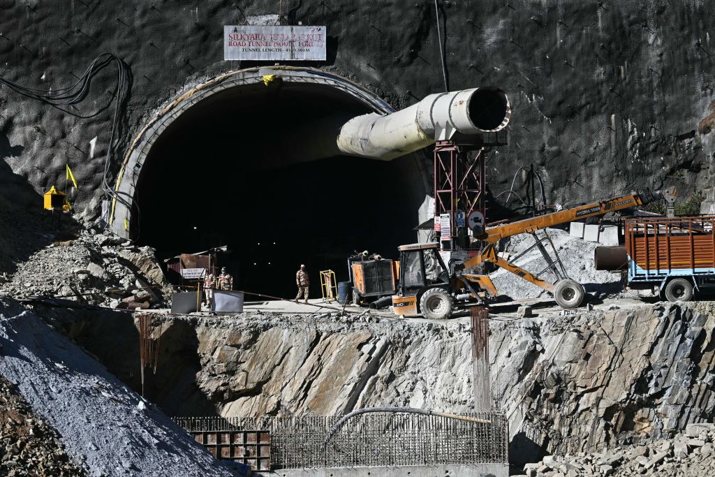 Security personnel stand at an entrance of the under construction road tunnel, days after it collapsed in the Uttarkashi district of India's Uttarakhand state on Nov. 21, 2023.