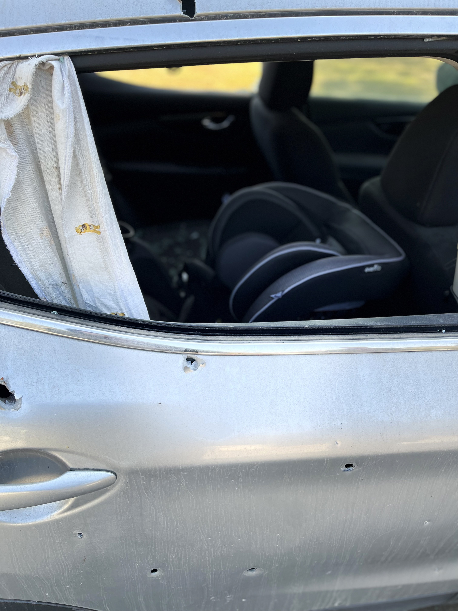 A car with a car seat is seen with bullet holes from Oct. 7.