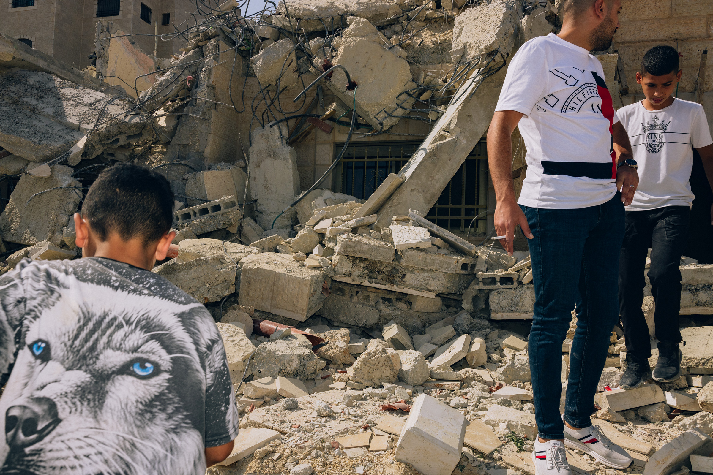 Neighbors in the Jalazon Refugee Camp, near the West Bank city of Ramallah, help members of the Nakhle family retrieve valuables that could be salvaged following the punitive home demolition of the six family home, on Oct. 28.