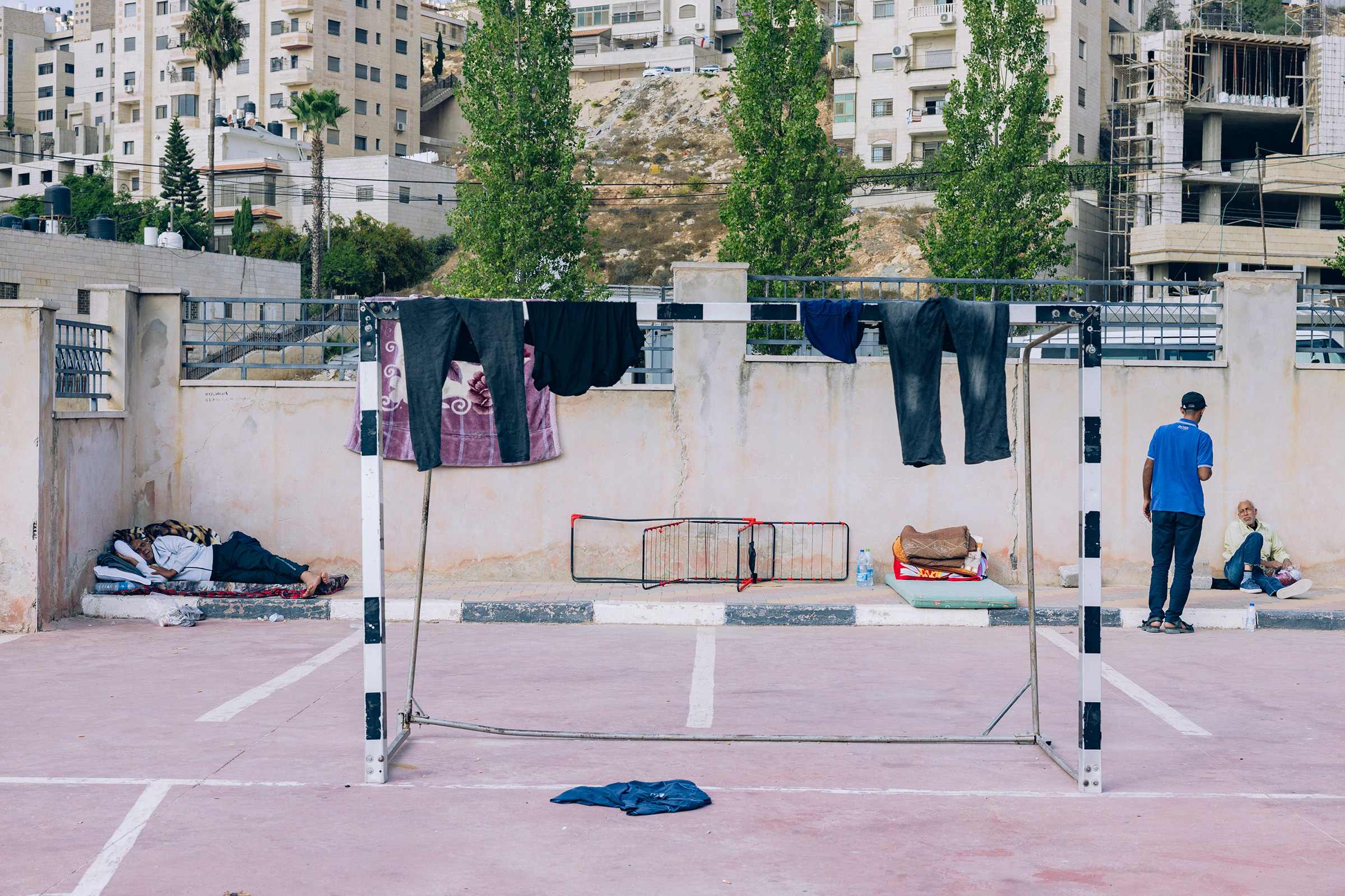 Clothes belonging to Gazan workers who were stuck inside Israel on Oct. 7th hang to dry on a soccer goal at the Redanna Sports Complex in the West Bank city of Ramallah, on Oct. 14.