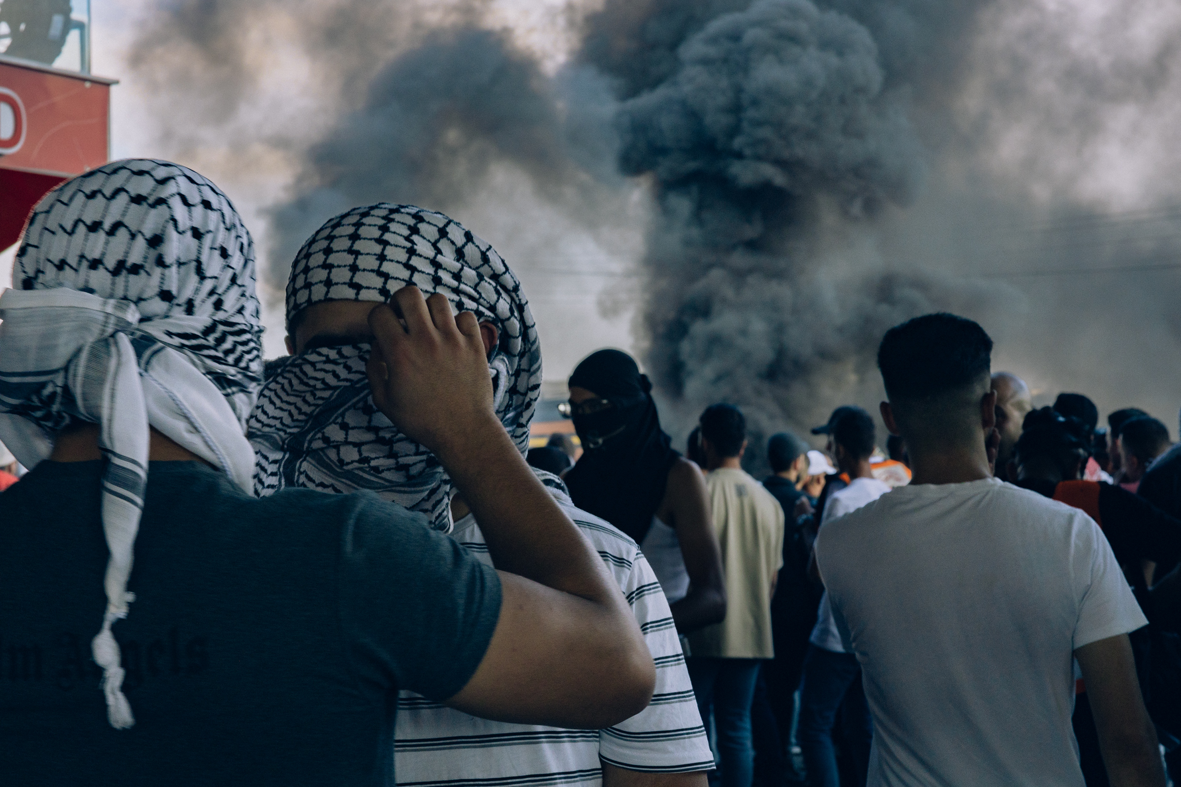 A young Palestinian man has his face shielded with a kuffiyeh during a confrontation with the Israeli occupation near the illegal Beit El settlement in the West Bank city of al-Bireh, on Oct. 13. The kuffiyeh, a traditional headdress, serves as a symbol of Palestinian identity.