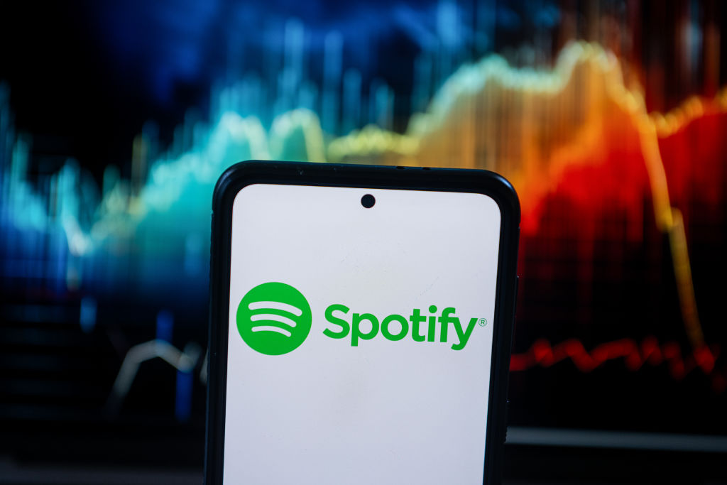 In this photo illustration a Spotify logo seen displayed on