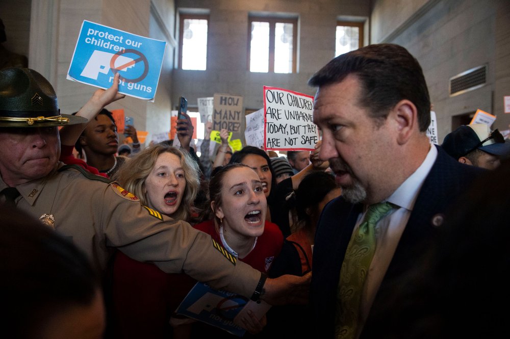 Addie Brue, 16, and Madeline Lederman, 17, shout "do something," with other protesters as Rep. Jeremy Faison, Chairman of the House Republican Caucus, walks towards the House chamber doors at the State Capitol Building in Nashville, Tenn., on March 30.