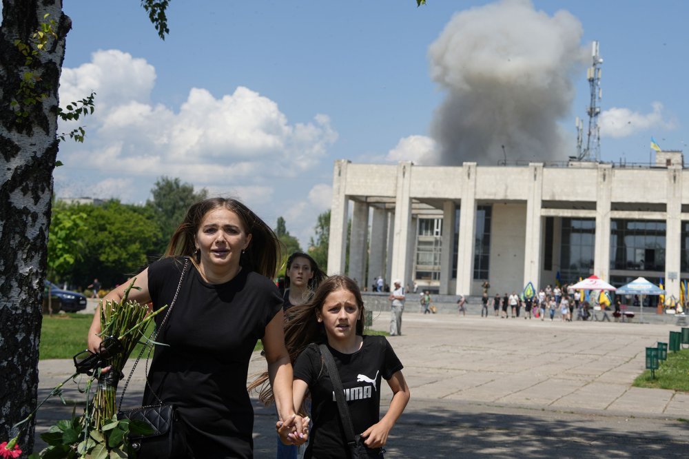 A family runs from an explosion after a Russian rocket attack on a residential neighborhood in Pervomaiskyi, Kharkiv region, Ukraine, on July 4.