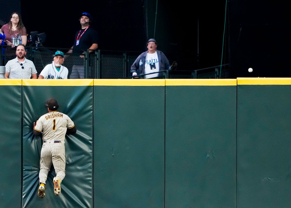 San Diego Padres center fielder Trent Grisham collides with the wall as the RBI triple from Seattle Mariners' Dylan Moore rolls along the top of the wall during the sixth inning of a baseball game in Seattle, on Aug. 8.