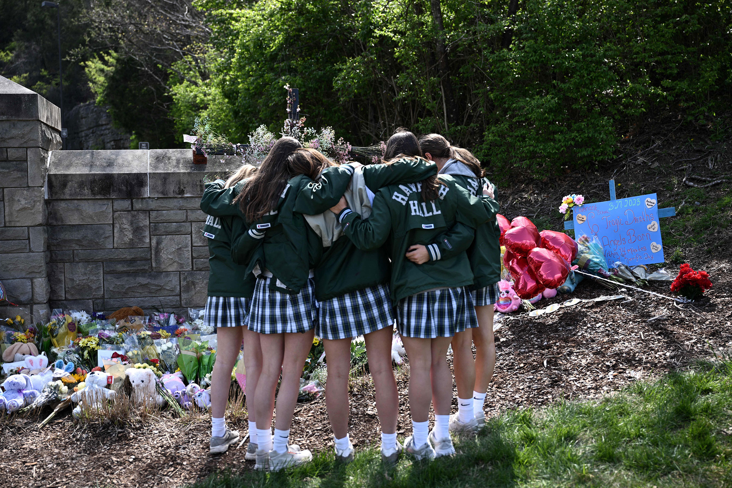A group of girls embrace in front of a makeshift memorial for victims by the Covenant School building at the Covenant Presbyterian Church following a shooting, in Nashville, Tenn., on March 28.
