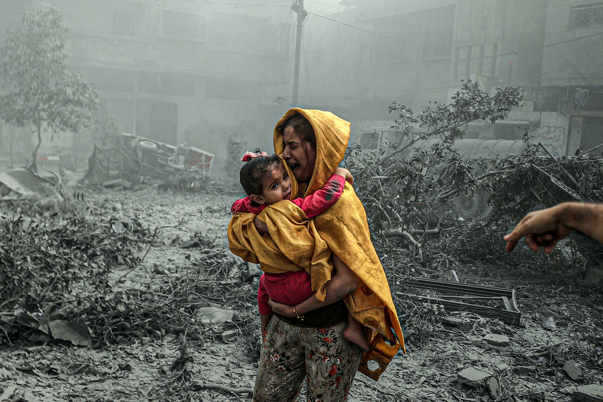 A woman holding a girl reacts after Israeli airstrikes hit Ridwan neighborhood of Gaza City, on Oct. 23.