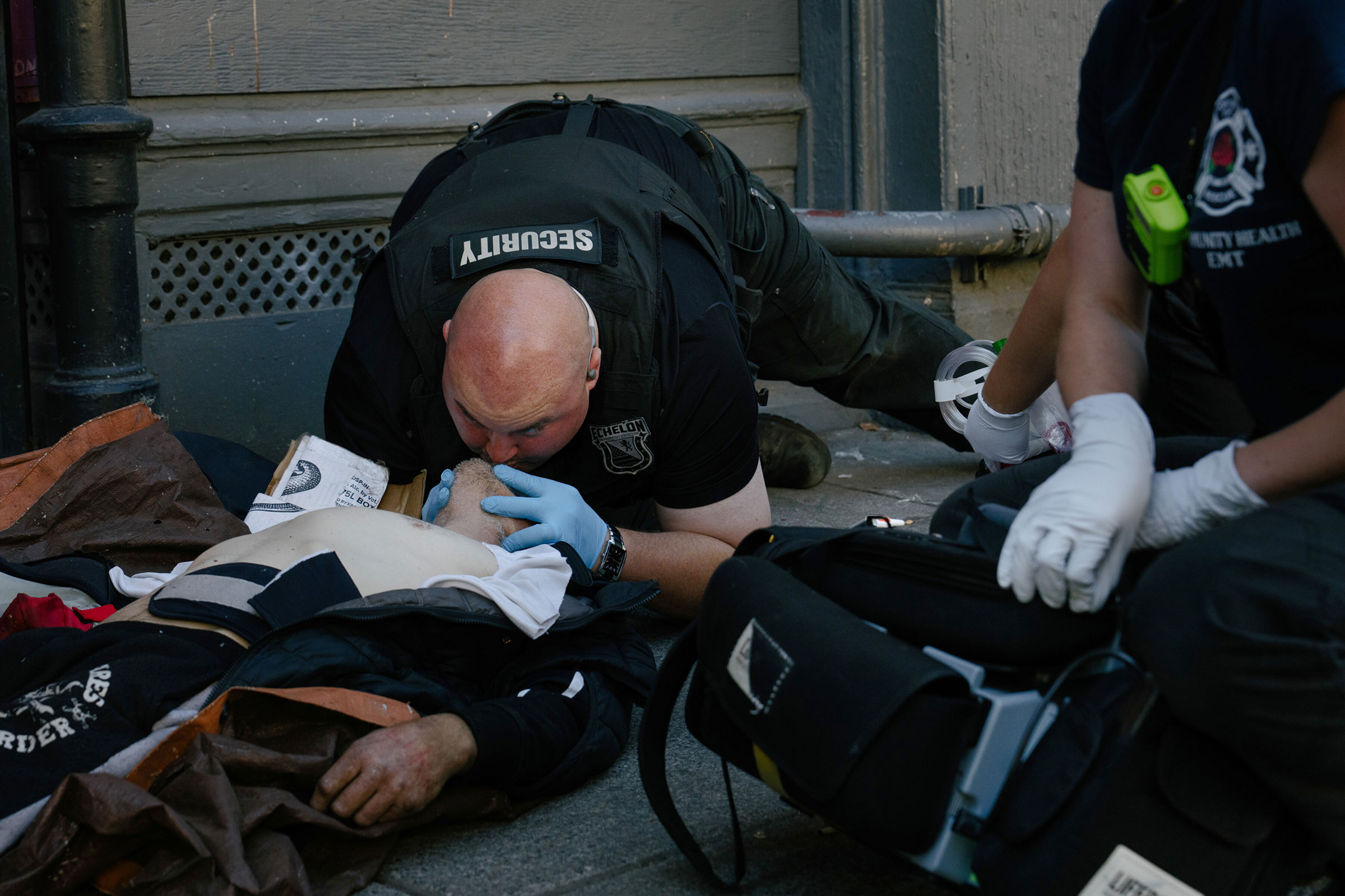 Security guard Michael Bock performs CPR on a man who overdosed, and regained conscious soon after, downtown Portland, Ore., Aug. 2, 2023. (Erin Schaff/The New York Times)