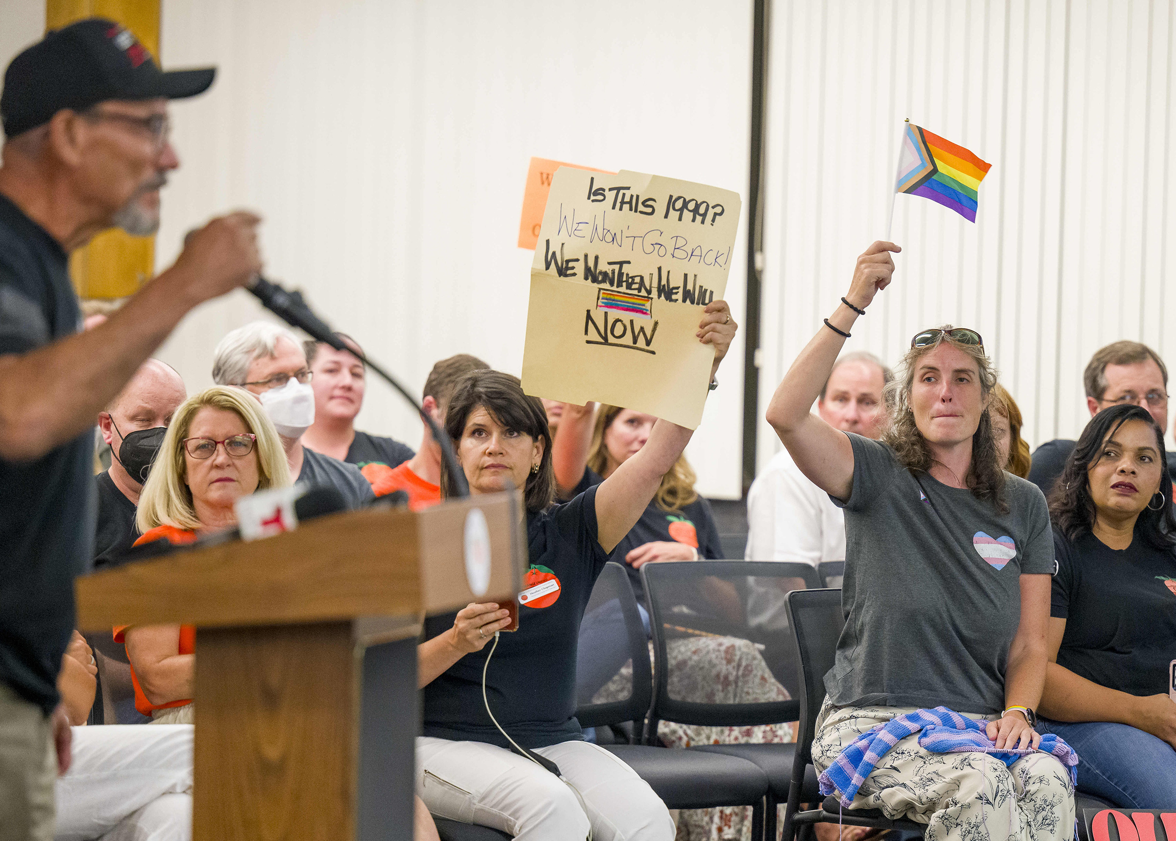 People opposed to a proposed policy that would require school staff to notify parents that their child is transgender, right, react to a speaker in favor of the policy during a meeting of the Orange Unified School District in Orange County, Calif., on Aug. 17, 2023. (MediaNews/Getty Images)