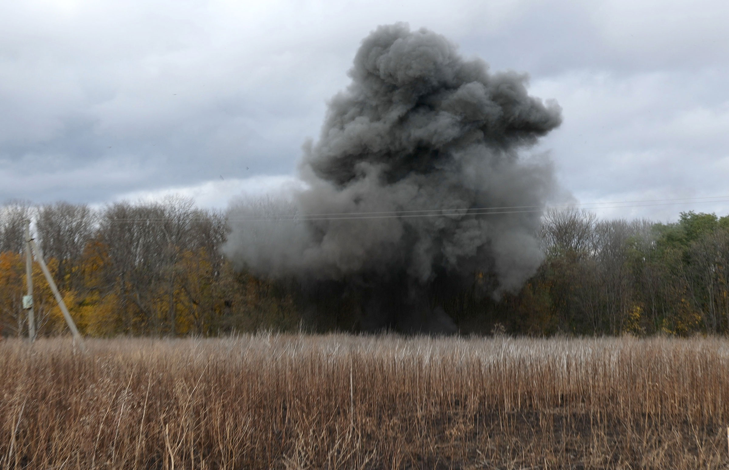 A plume of smoke rises after a controlled explosion as a consolidated squad of the Explosives Service of Ukraine carries out demining work in Kharkiv Region, on Oct. 23, 2023.