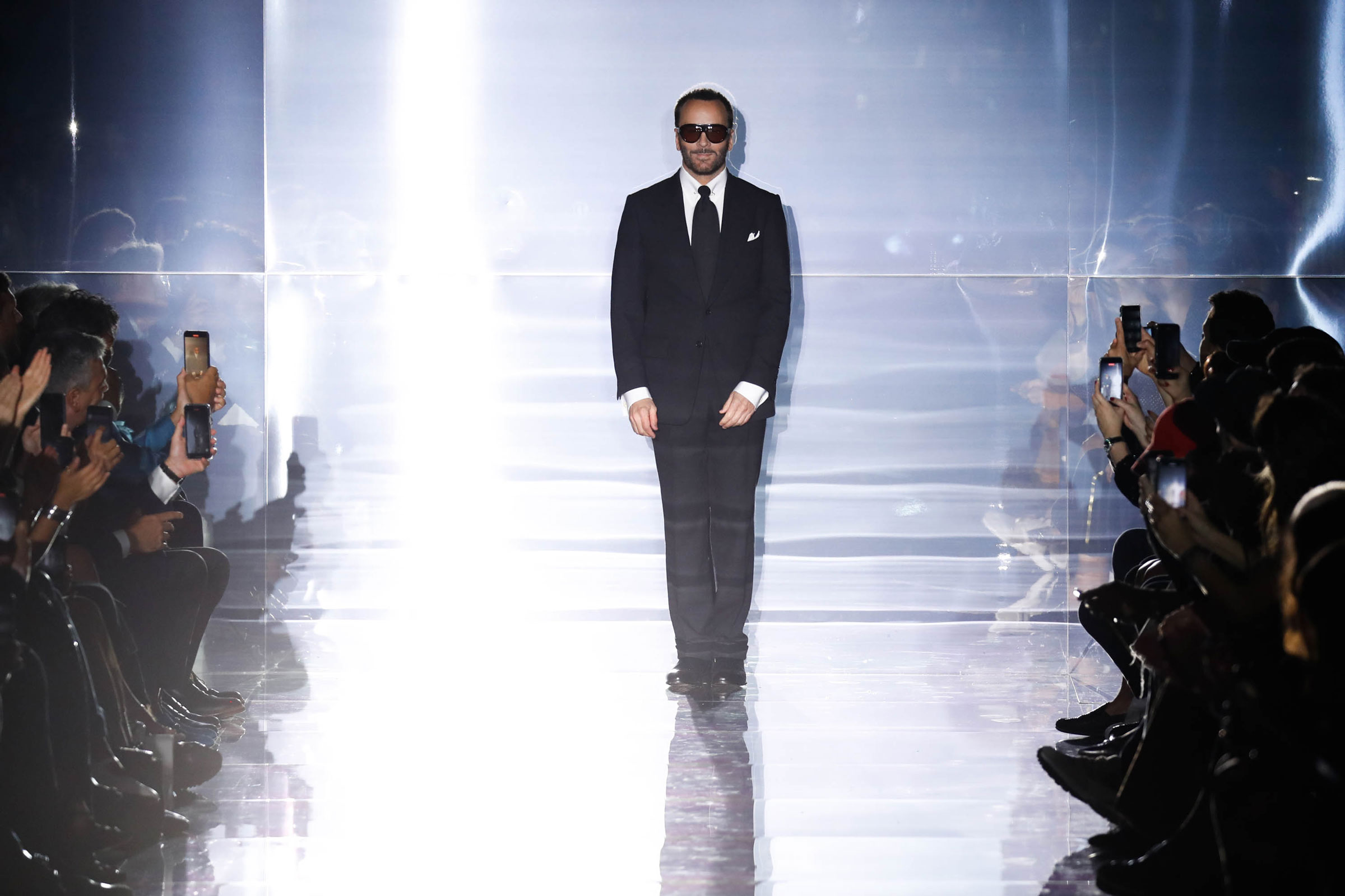 Designer Tom Ford walks the runway at the conclusion of his fashion show