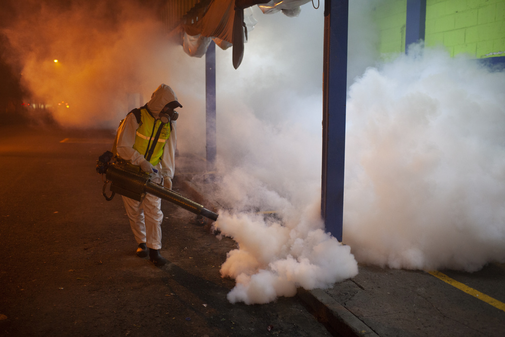 A city worker fumigates a market at night in the fight against the <em>Aedes aegypti </em>mosquito, which transmits the dengue virus, in Guatemala City, Guatemala, on Aug. 31, 2023. (Sandra Sebastian—picture-alliance/dpa/AP)
