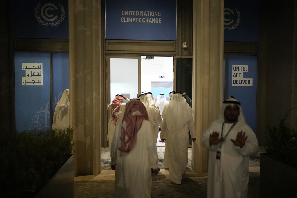 Delegates walk into a meeting at COP28 as negotiations continued in Dubai, Dec. 13, 2023. (Rafiq Maqbool—AP)