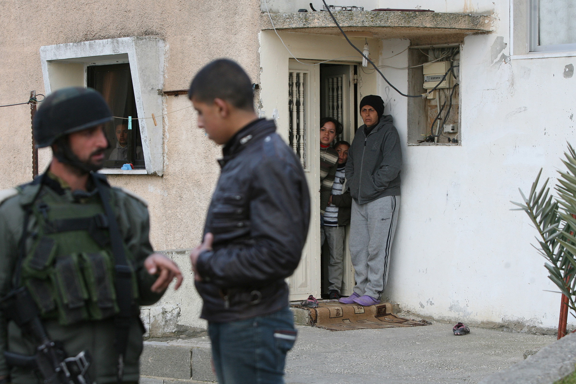 Israeli soldiers question Palestinians and search houses in the village of al-Tabaqa, near Dura in the southern West Bank region of Hebron, on Feb. 16, 2012.