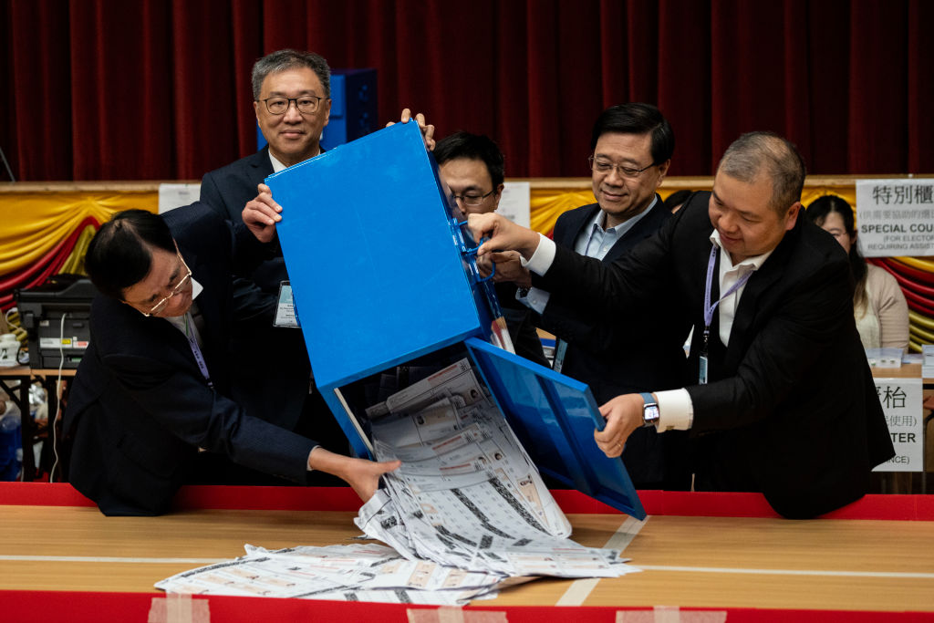 Hong Kong Chief Executive John Lee is helping to pour out votes from the ballot box at a polling station in Hong Kong, China, on Dec. 10, 2023.