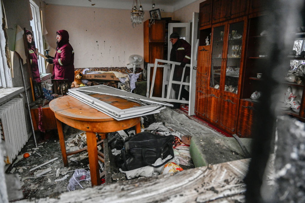 Communal workers fix broken windows in a destroyed house that was damaged as a result of a ballistic missile attack by the Russian army in Kyiv. (Sergei Chuzavkov—SOPA Images/LightRocket/Getty Images)