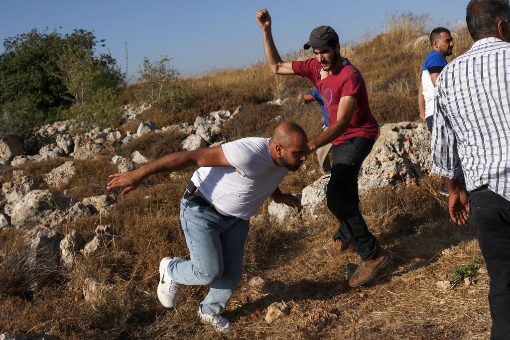 Palestinians scuffle with Israeli settlers who set up tents on lands in Halhoul village north of Hebron in the occupied West Bank, on Aug. 1, 2023.