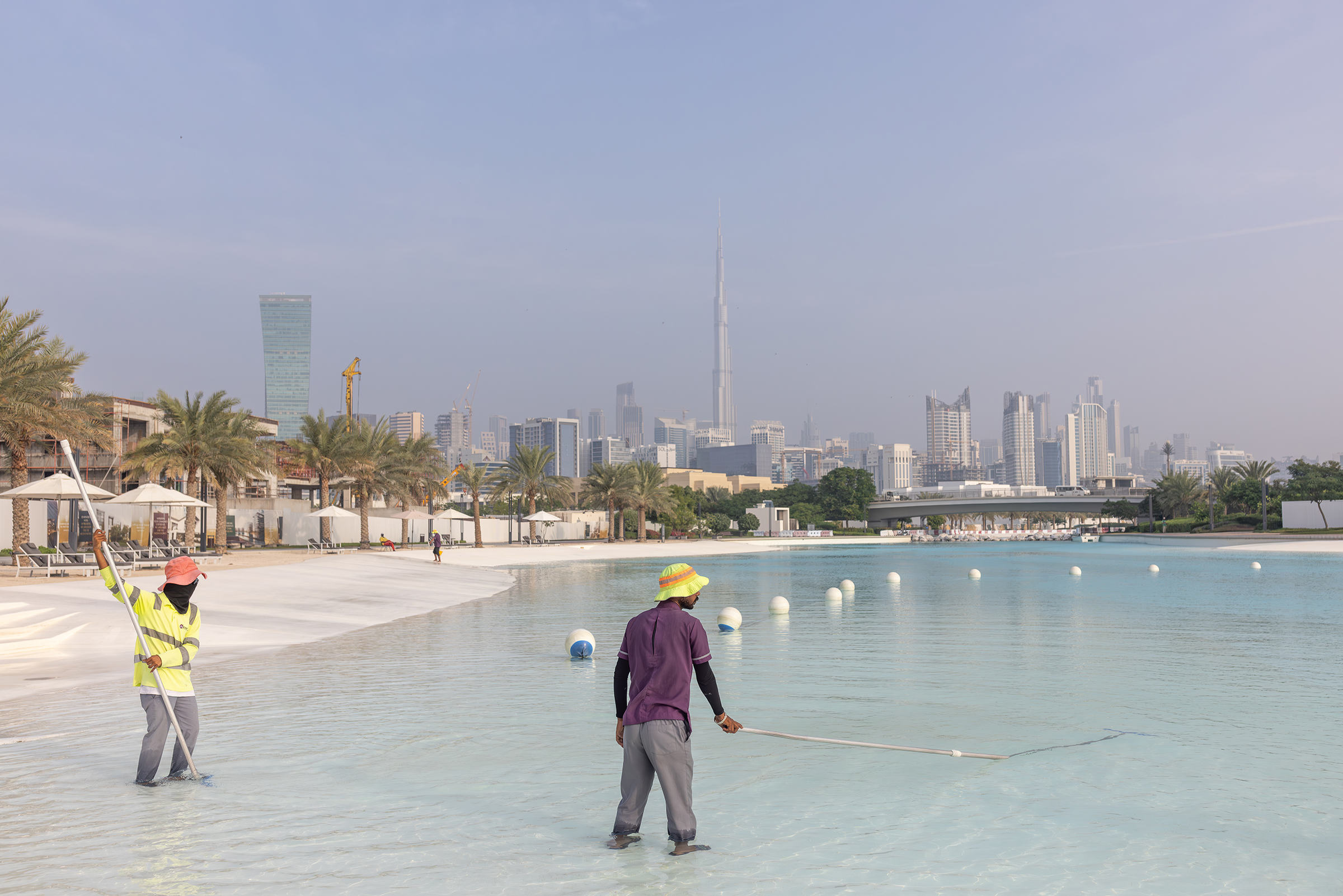 Workers clean the fresh water lagoon at District One on Nov. 21, 2023 in Dubai.