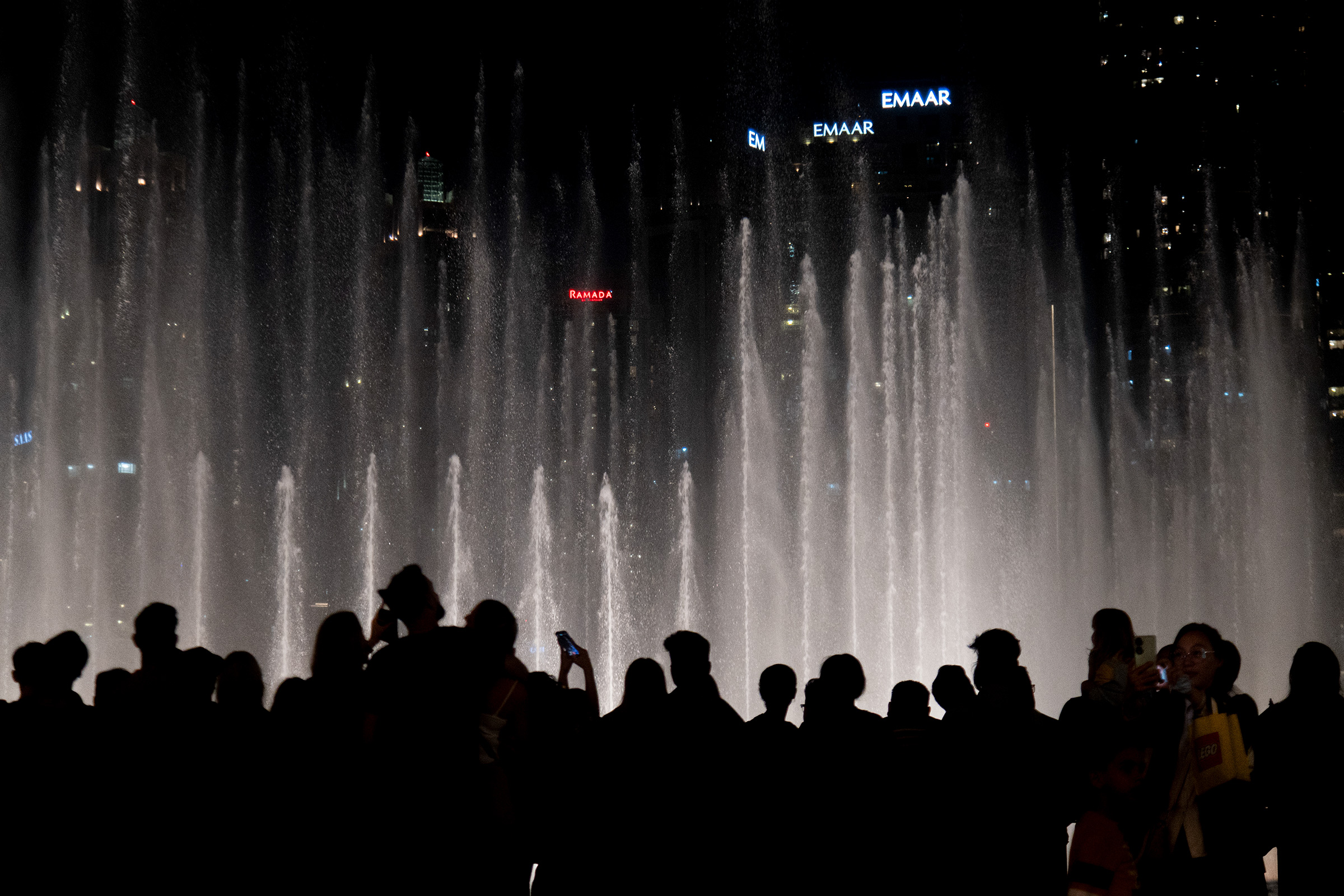People make photographs and record videos on their phones of a fountain show at the Dubai Fountains on Dec. 21, 2023.