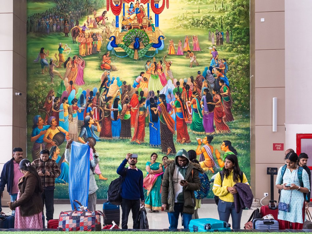 Ayodhya's new airport, pictured on Jan. 17 at two weeks old, features motifs from the Indian epic Ramayana based on the life of Ram. In the background is a depiction of the scene when Ram returns with Sita to Ayodhya after a 14-year exile. In the foreground, a more mundane reality plays out. A couple is worried about their missing baggage. Others are struggling to fit the giant mural into their selfie or making calls to check on their airport pick-up.