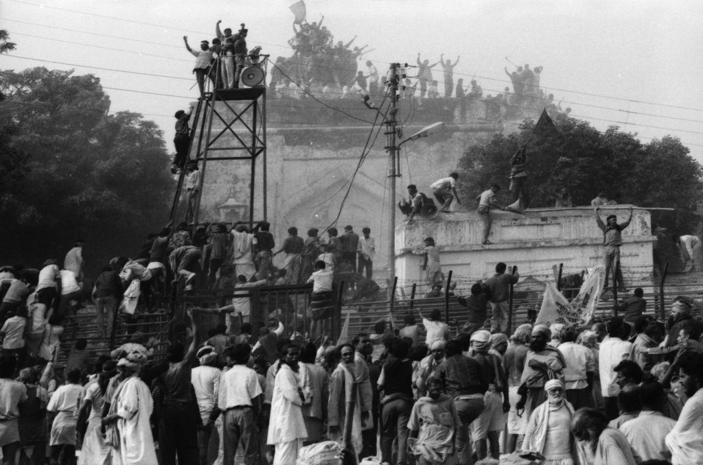 Hindu fundamentalists climb the dome of Babri Masjid in Ayodhya to demolish the structure on Dec. 06, 1992.