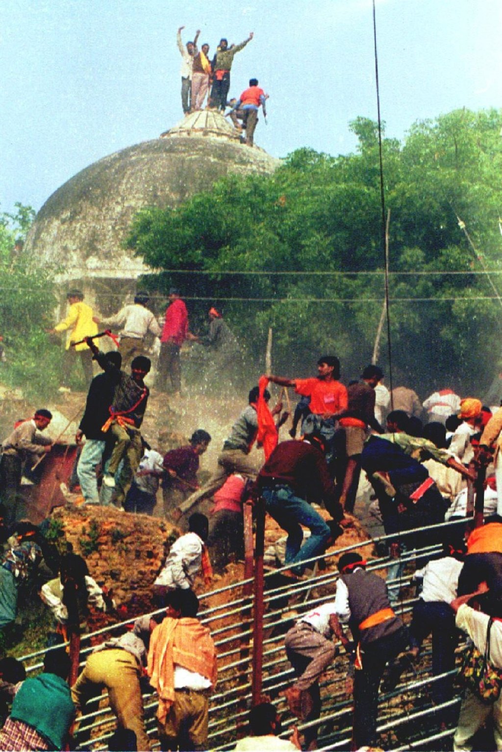 Hindu militants storm the Babri Masjid in December 1992, climbing atop the building's dome as they demolish it to clear the site for a Hindu temple.